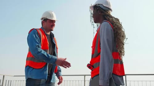Two construction worker handshake at job site, team engineer or architect handshake.