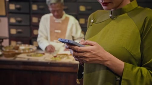 Woman Uses Phone While Man Works With Medicine