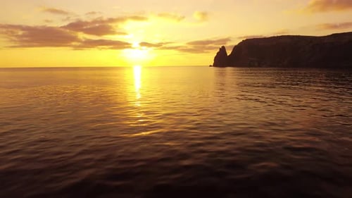 Aerial View on Sunset Over Calm Sea and Volcanic Rocky Shores