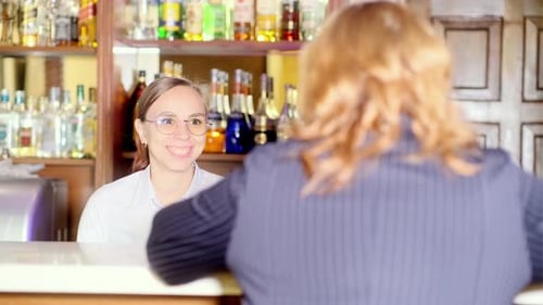Cheerful Bartender Woman Talking to Client in Cafe