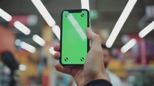Close Up Man Hand Holding Use Phone with Vertical Green Screen in Supermarket Silhouette Shopping