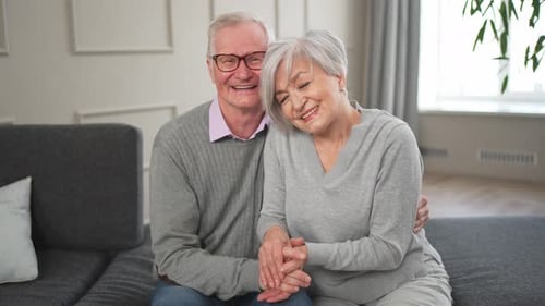 Loving Senior Couple Smiling on Couch Together