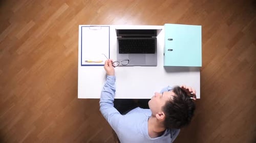Man sitting at desk with laptop and stationery