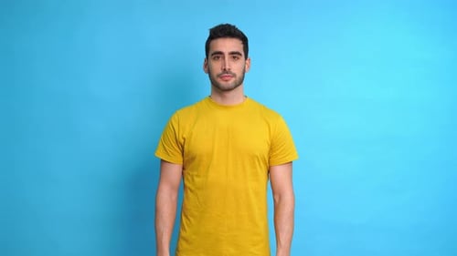 Man Shrugs Shoulders in Confusion Against Blue Backdrop