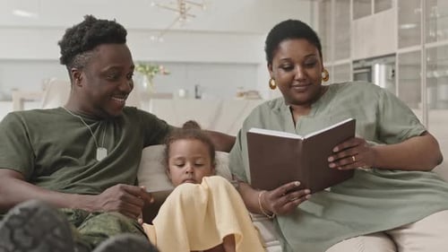 Happy Family Reading a Book Together on the Couch