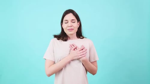 Woman Has Hands Clasped and Held to Chest