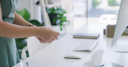 4k video footage of an unrecognisable businesswoman sanitising her keyboard in a modern office