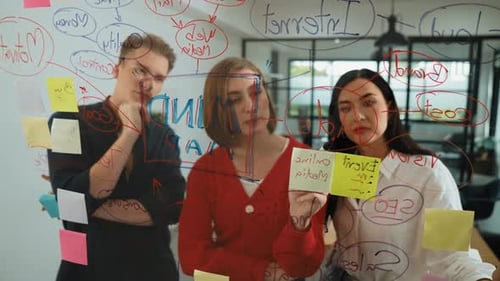 Team Brainstorming and Planning Together on Glass Wall