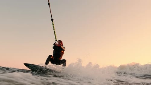 Man wakeboarding on the ocean at sunset