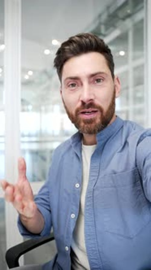 POV Vertical. Confident businessman talking on video call using a phone in business office