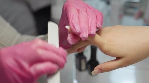 Manicurist Filing Woman's Nails at Nail Salon