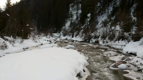 Small Frozen River Bank in snowy landscape during wintertime