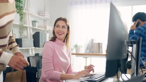 Caucasian attractive man giving take away food to colleagues in office.