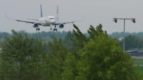 Airplane Landing at Airport on Cloudy Day