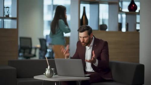 Bearded Man Video Conferencing in a Modern Office