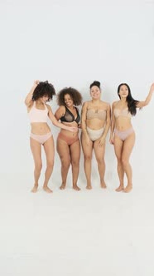 Four Smiling Women Posing in Bright Studio