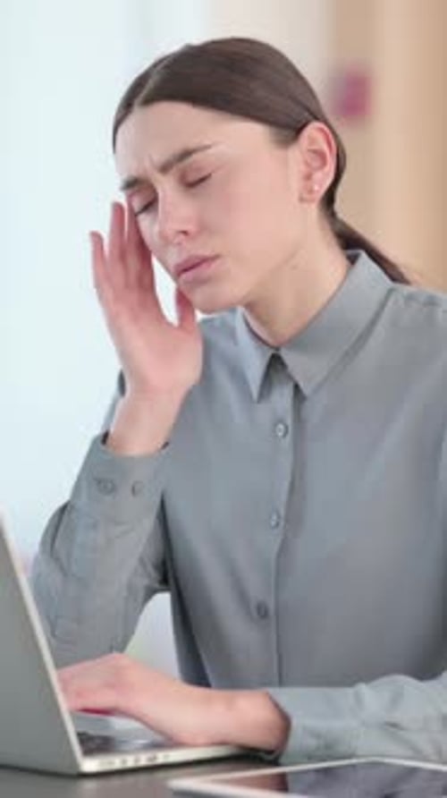 Woman Working on Laptop at Desk with Headache