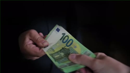 Pack of hundred dollar bills that two people pull on themselves and cannot share, close up