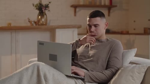 Young Adult Man Using Laptop on Couch