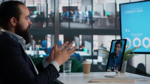 Man Video Conferencing with Colleague on Tablet Indoors