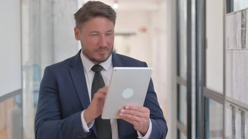 Adult Man Using Tablet in Modern Office