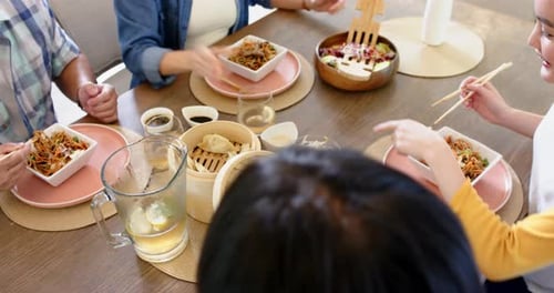 Friends Enjoying Meal of Asian Cuisine at Home
