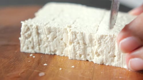 Top View of Hands Cutting Tofu with Knife