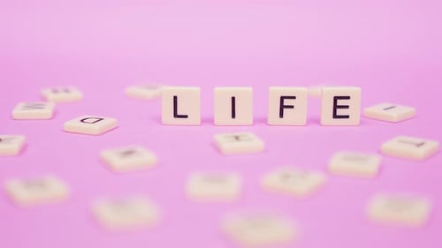 Life Spelled Out in Letter Tiles on Pink