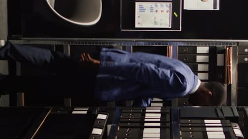 Professional Man Reviews Documents at Office Desk