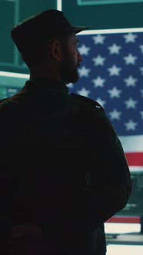 Man in Uniform Stands Before American Flag