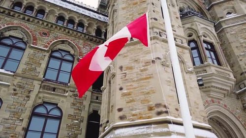 Canadian Flag Waving Proudly in Front of Building