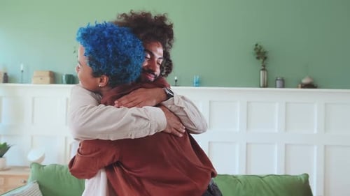 Young Ethnic Man and Woman Hug Each Other After Separation Stand in House