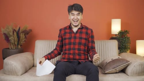 Man Reacting to News while Sitting on Couch