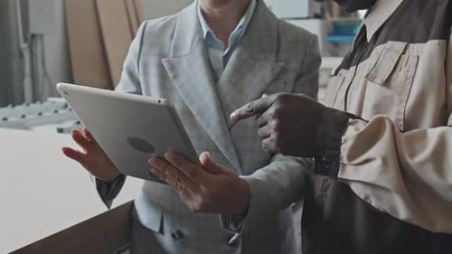 Female Manager and Factory Worker Using Tablet