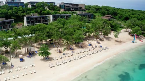 Drohnenaufnahme des Ferienstrandresorts aus der Luft. Blick auf den leeren Strand und das pulsierende türkisfarbene Meer.