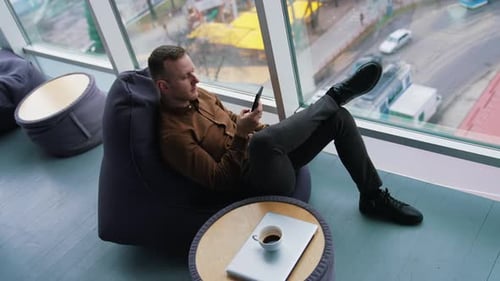 Businessman relaxing on view from office window