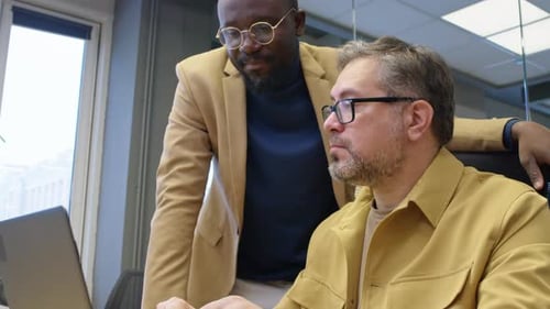 Zwei multiethnische Mitarbeiter brainstormen Projektideen