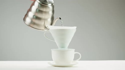 Water Pouring into a Coffee Filter in Cup