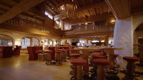 Hotel dining room with wooden chair with textile material and wooden tables.