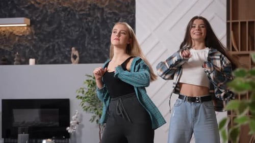 Two Young Women Dancing and Having Fun Indoors