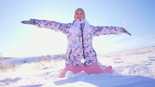 Girl Plays in the Snow on Bright Winter Day