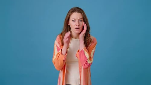 Distressed Woman Checks Hair Against Blue Background