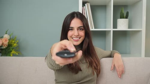 One Young Woman Using the Television Remote Controller to Change the Channel Adult Caucasian Female