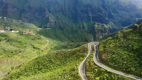 Cars Driving Through Sharp Turn on Winding Zig Zag Serpentine Road in Mountains