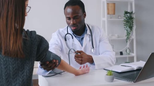 Doctor Taking Patient's Blood Pressure in Office