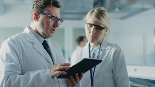 Scientists Review Data on Tablet in Lab