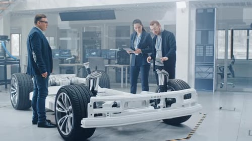 Automotive Engineers Discuss Car Design in Modern Lab