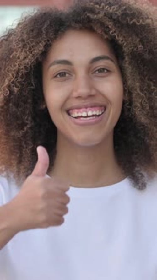 Woman Smiling and Giving Thumbs Up Gesture