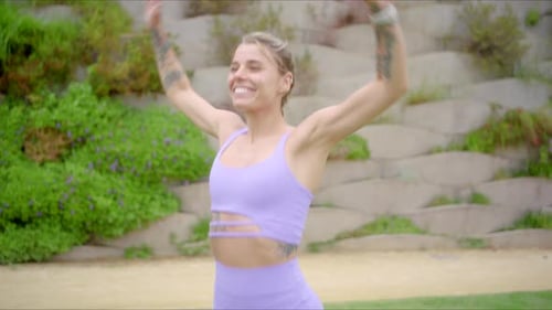 Woman Doing Jumping Jacks in a Park