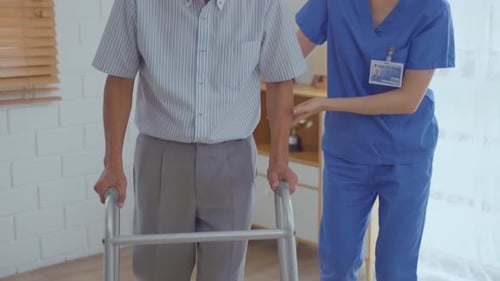 Senior Man Uses Walker with Assistance of Nurse